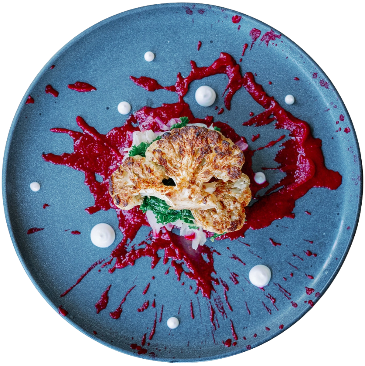 Cauliflower steak with red sauce on a blue plate