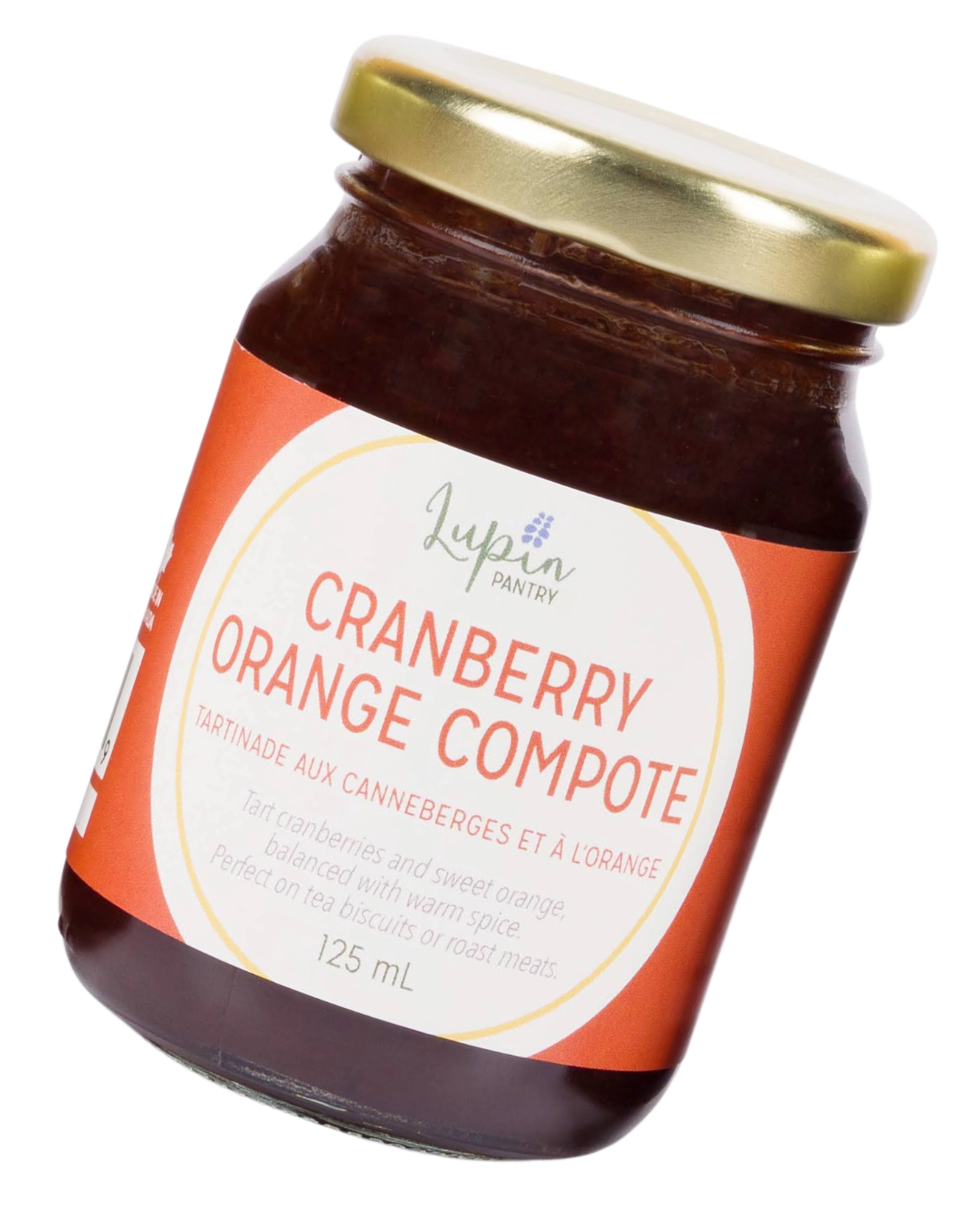 Tilted jar of cranberry orange compote with a gold lid on a transparent background.