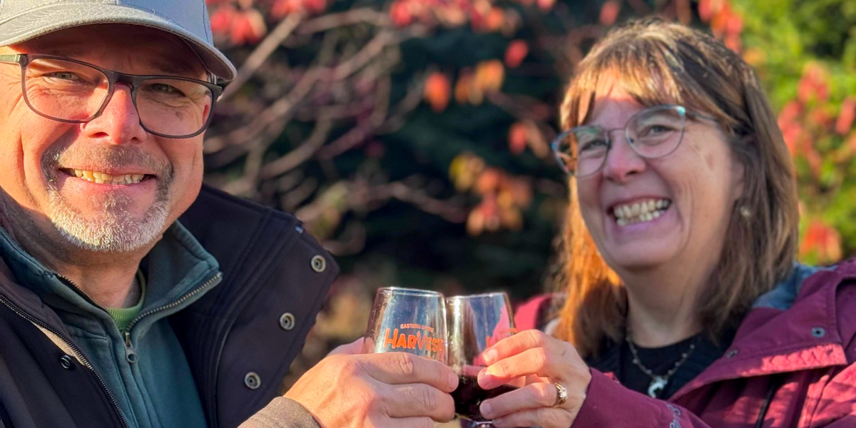 guests-toasting.png
Two smiling guests raising Harvest Food Festival glasses, with autumn foliage behind them.