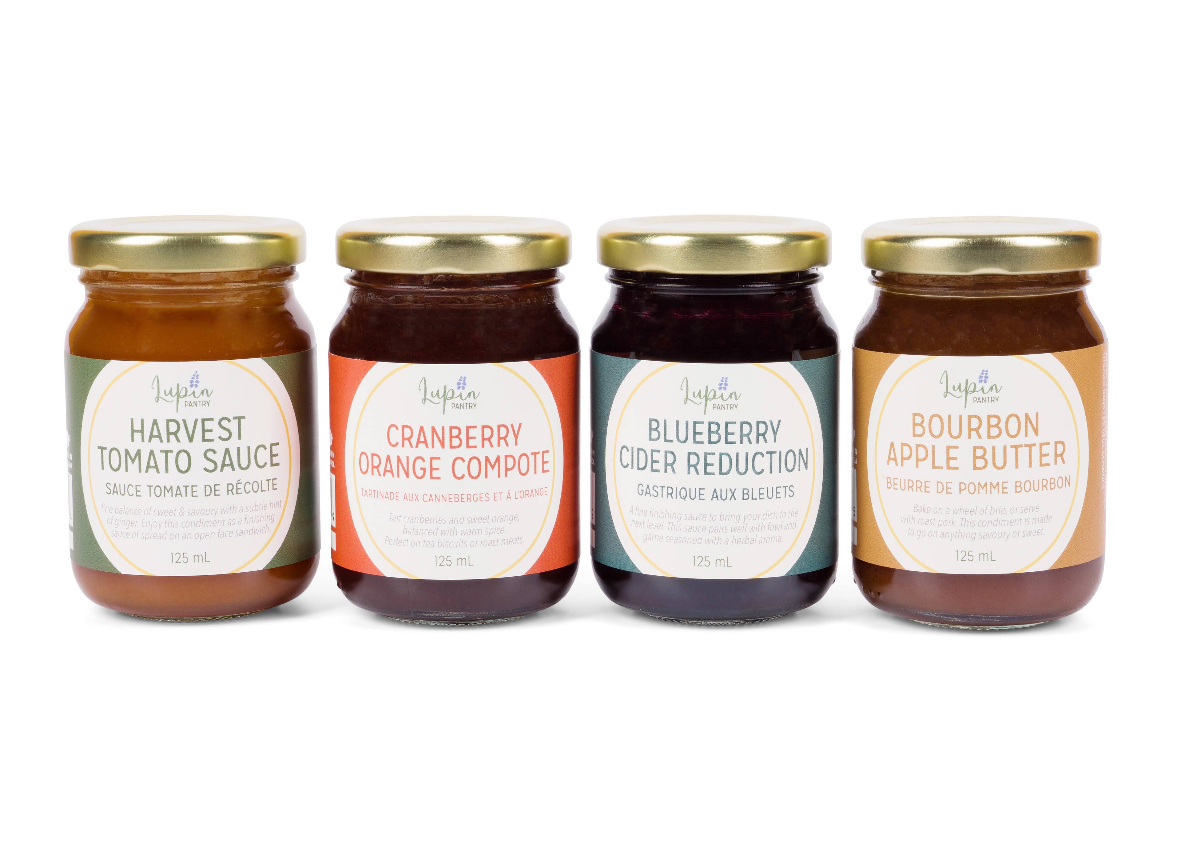 Four jars of different flavors of preserves on a white background